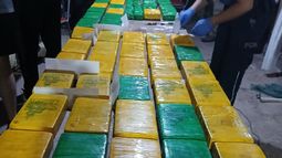 Paquetes con la cocaina incautada durante allanamientos. Los cuatro principales sospechosos permanecen prófugos. Paquetes con la cocaina incautada durante allanamientos. Los cuatro principales sospechosos permanecen prófugos.